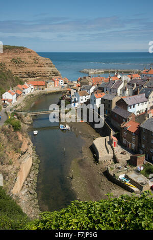 Sonnigen Blick auf malerische Staithes, North Yorkshire, GB, UK - malerische Fischerdorf mit zusammengekauert auf dem Land, Naturhafen und blauer Himmel. Stockfoto