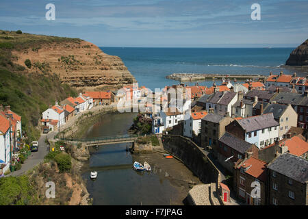 Sonnigen Blick auf malerische Staithes, North Yorkshire, GB, UK - malerische Fischerdorf mit zusammengekauert auf dem Land, Naturhafen und blauer Himmel. Stockfoto