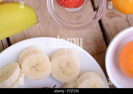 gesunde Erdbeeren und Bananen Scheiben auf hölzernen Hintergrund Stockfoto