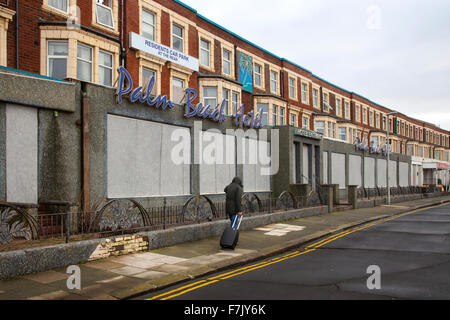 Mann mit Koffer durch Nord-West Seafront Resort Hotels in permanentem Verfall. Dies waren die Bed and Breakfast Hotels, die den beliebten Ferienort anheizten. Viele der Grand Hotels in South Shore sind jetzt verladen, Bemühungen wurden unternommen, um die Stadt moribund Tourismusindustrie wieder zu beleben, aber die vergessene Lancashire Resort Golden Mile ist jetzt blasse Spiegelung seiner ehemaligen selbst. Bis 2000 einige Bed-and-Breakfast-Preise waren so niedrig wie £10 pro Nacht gefallen, die kein Geld für Investitionen in Verbesserungen links. Stockfoto