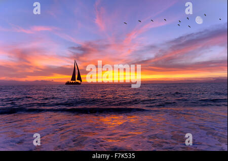 Segelboot Sonnenuntergang Silhouette ist eine bunte, lebendige orange und gelb Wolkengebilde s Stockfoto