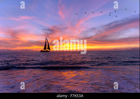 Segelboot Sonnenuntergang Silhouette ist eine bunte, lebendige orange und gelb Wolkengebilde Sonnenuntergang. Stockfoto