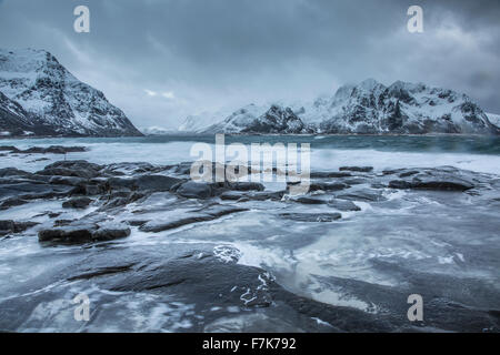 Schneebedeckte Berge hinter kalten Ozean, Vareid, Lofoten Inseln, Norwegen Stockfoto