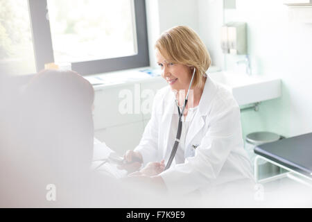 Arzt überprüft Patient Blutdruck im Untersuchungsraum Stockfoto