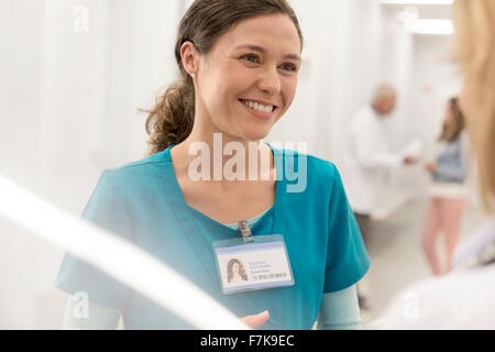 Lächelnde Krankenschwester Rücksprache mit Arzt im Krankenhausflur Stockfoto