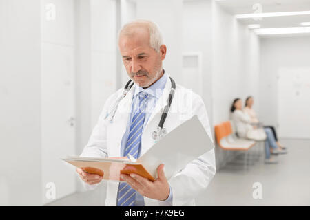 Arzt machen runden Krankenakte im Krankenhausflur überprüfen Stockfoto