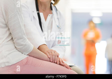 Arzt beruhigend Patient im Korridor Stockfoto