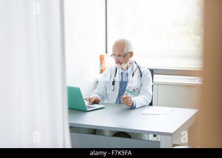 Arzt, arbeitet am Laptop in Arztpraxis Stockfoto