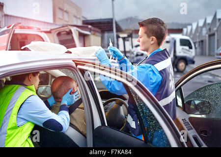 Rettungskräfte, die tendenziell Auto Unfallopfer in Auto Stockfoto