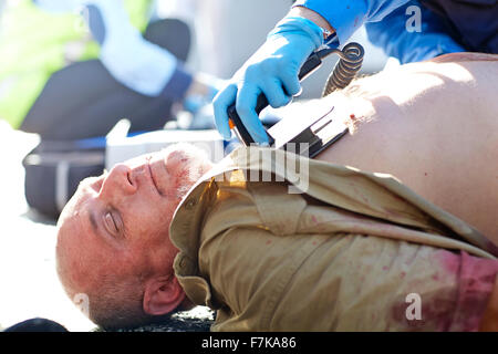 Retter mit Defibrillator auf unbewusste Auto Unfallopfer Stockfoto