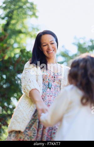 Lächelnde Mutter und Tochter, die Hand in Hand im freien Stockfoto