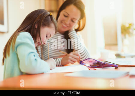 Mutter Tochter tun Hausaufgaben zu beobachten Stockfoto