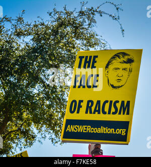 Ein Donald Trump Demonstrant hält ein Schild, das liest "Das Gesicht des Rassismus" mit einem Bild von Trump bei einer GOP-Kundgebung Stockfoto