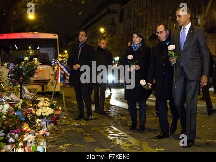 US-Präsident Barack Obama zusammen mit französische Präsident Francois Hollande und Paris Bürgermeister Anne Hidalgo vorzubereiten, eine Rose in einem behelfsmäßigen Denkmal vor Bataclan, die Opfer der Terroranschläge 29. November 2015 in Paris, Frankreich zu Ehren zu stellen. Stockfoto