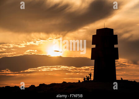 Touristen besuchen das Denkmal für die Bretonen des freien Frankreich / Kreuz des Pen Hir bei Sonnenuntergang, Pointe de Pen-Hir, Bretagne, Frankreich Stockfoto