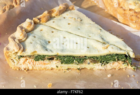 Stück hausgemachte Torte mit Lachs und Spinat. Foto auf der Frühjahrsmesse unter freiem Himmel an einem sonnigen Tag. Close-up. Stockfoto