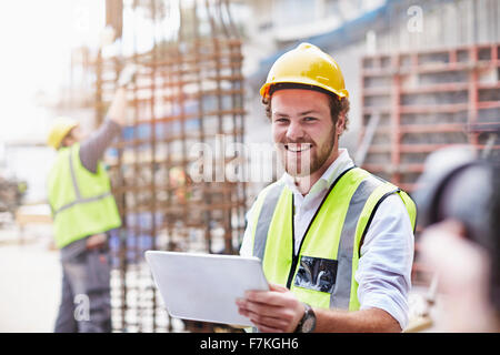 Porträt zuversichtlich Bauarbeiter mit digital-Tablette auf Baustelle Stockfoto