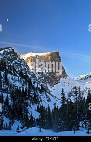 Mond über Hallett Peak (12.713 ft.) im Winter, Rocky Mountain Nationalpark, Colorado USA Stockfoto