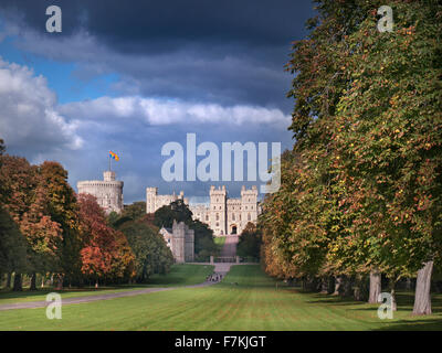 Windsor Castle Flying Royal Standard sah den langen Spaziergang mit Spaziergängern in herbstlicher Farbe mit dramatischen Wellen von Sonnenlicht und Sky Berkshire UK Stockfoto