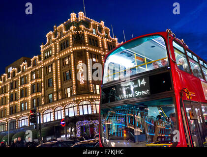 Das Kaufhaus Harrods in der Abenddämmerung mit Verkauf leuchtet Shopper vorbei an Taxis und roten Bus Knightsbridge London SW1 Stockfoto