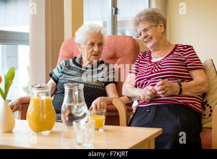 Ältere Damen genießen einen Witz in einem Pflegeheim Stockfoto