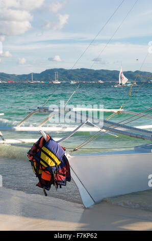 Rettungswesten, hängen auf einem Boot an einem tropischen Strand Stockfoto