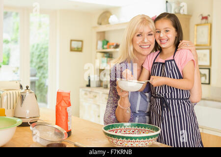 Porträt, Lächeln, Großmutter und Enkelin in Küche Backen Stockfoto