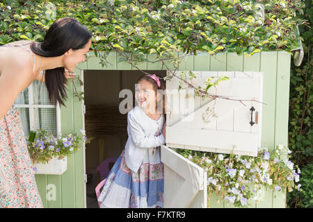 Mutter und Tochter am Playhouse in Garten Stockfoto