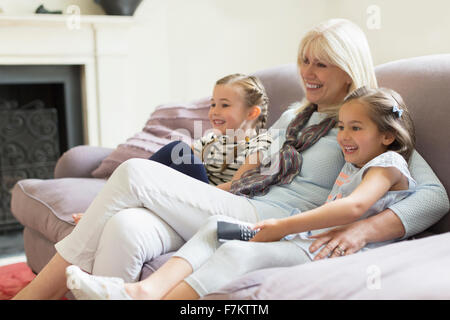 Großmutter und Enkelinnen Fernsehen auf dem Sofa im Wohnzimmer Stockfoto