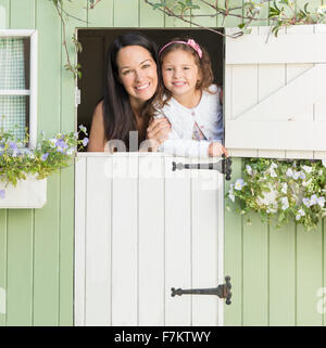 Porträt, Lächeln, Mutter und Tochter im Spielhaus-Fenster Stockfoto