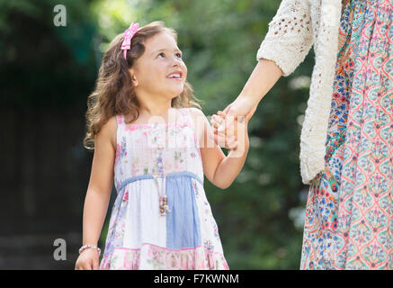 Lächelndes Mädchen in Tracht an der Mutter hand Stockfoto