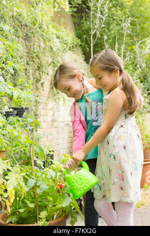 Mädchen Bewässerung von Pflanzen im Garten Stockfoto