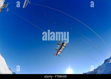 Skilift - verwenden Sie glücklich Skifahrer Vertikaltransport auf Ski-Urlaub am sonnigen Wintertag im Schnee Stockfoto