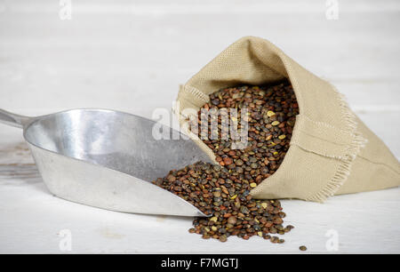 Linsen in einem kleinen hessischen Beutel mit Küche-Schaufel Stockfoto