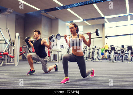 junger Mann und Frau mit Langhantel im Fitness-Studio trainieren Stockfoto
