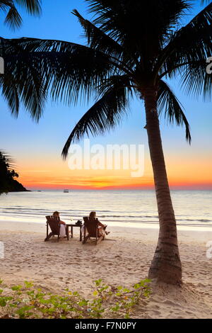 Touristen am tropischen Strand nach Sonnenuntergang, Insel Koh Samet, Thailand Stockfoto