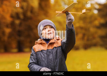 glückliche kleine Junge spielt mit Spielzeug Flugzeug im freien Stockfoto