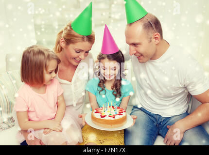 glückliche Familie mit zwei Kindern in Partyhüte zu Hause Stockfoto