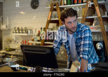 Café-Besitzer, die hinter der Kasse stehen Stockfoto