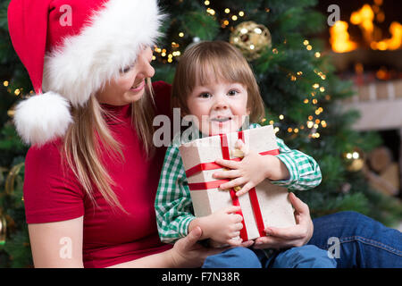 Mutter weared Santa und Kind Junge mit Weihnachtsgeschenk Stockfoto