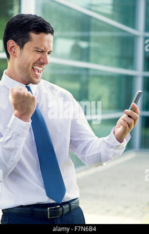 Geschäftsmann, die gute Nachricht per Handy empfangen Stockfoto