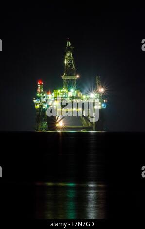 Eine Nahaufnahme der Nacht von der Ölbohrplattform beleuchtet auf der Küste von Limassol in Zypern. Die Bohrinsel schwimmt auf der mir Stockfoto