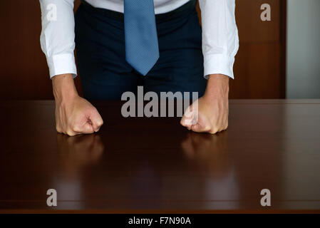 Geschäftsmann schlagen Fäuste auf den Tisch, beschnitten Stockfoto