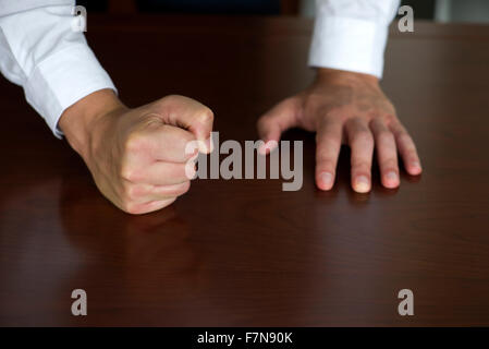 Geschäftsmann hämmerte Faust auf den Tisch, beschnitten Stockfoto