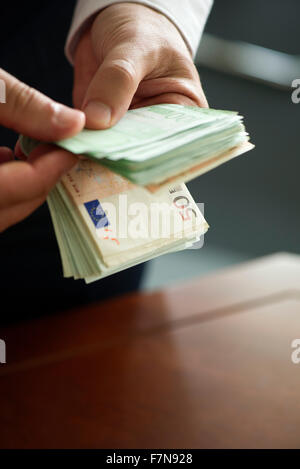 Mann zählen Stapel von Bargeld, beschnitten Stockfoto