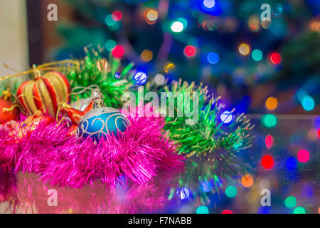 Weihnachten Silvester Spielzeug auf einem unscharfen Hintergrund von Weihnachtsbäume und Girlanden. Stockfoto