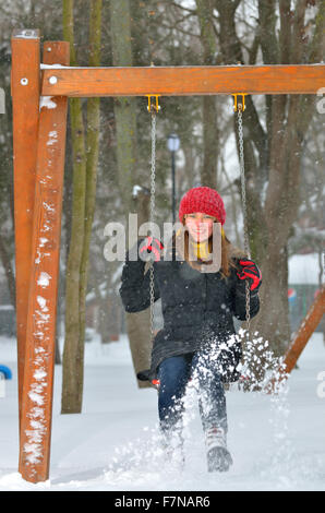 Teen Mädchen Schaukel auf verschneiten Wintertag Stockfoto