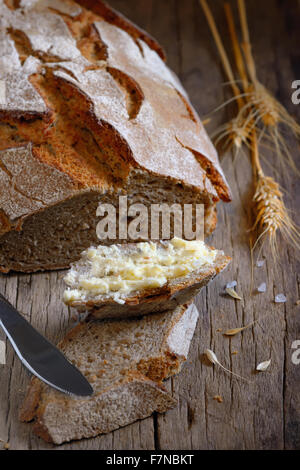 Frische hausgemachte Brot und Butter auf alten Holztisch Stockfoto