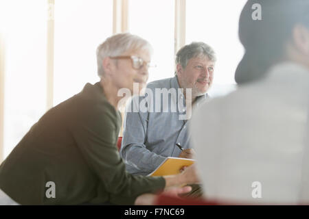 Aufmerksame Geschäftsleute hören in treffen Stockfoto