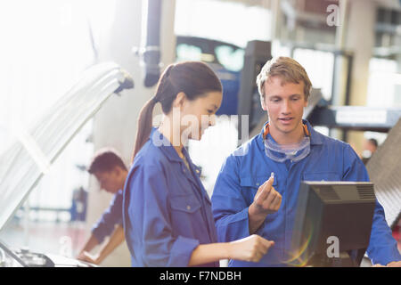 Mechanik Diskussion Teil am Computer im Auto Reparaturwerkstatt Stockfoto